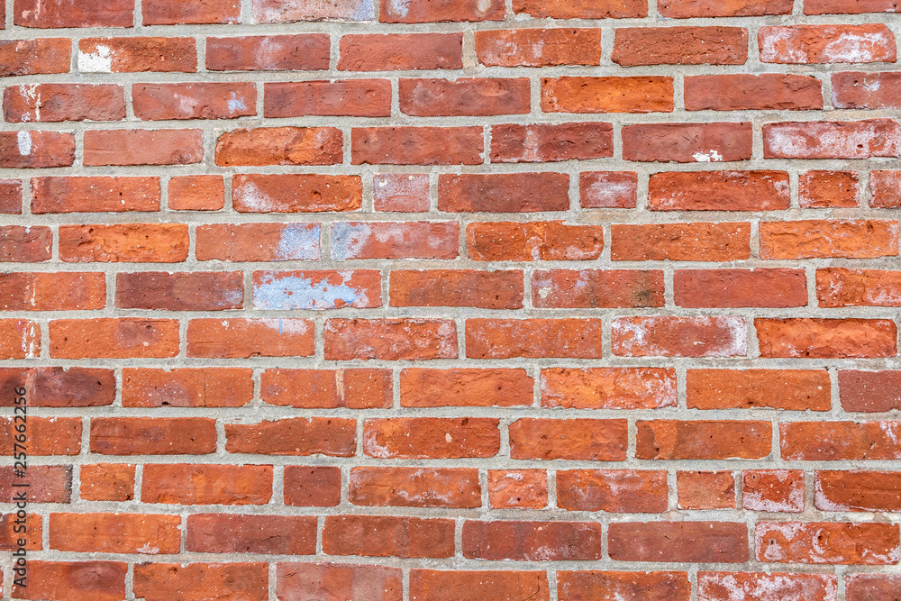 Obraz premium Old weathered red bricks with paint splatter.