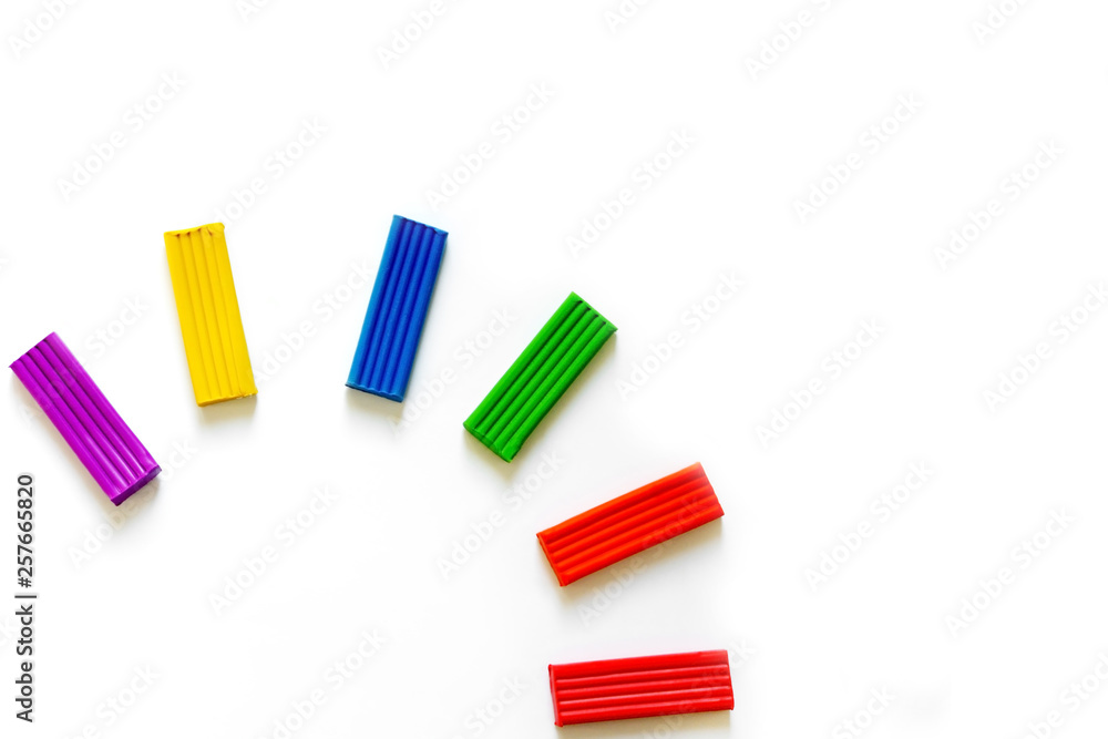 Multi-colored plasticine different shapes on a white background. How to organize classes with children at home. Motor development. Development of children's hands. Concept of education. Multi-colored plasticine different shapes on a white background. How to organize classes with children at home. Motor development. Development of children's hands. Concept of education.