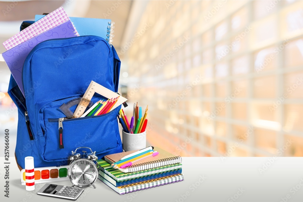 Colorful school supplies in backpack on blurred background Stock Photo