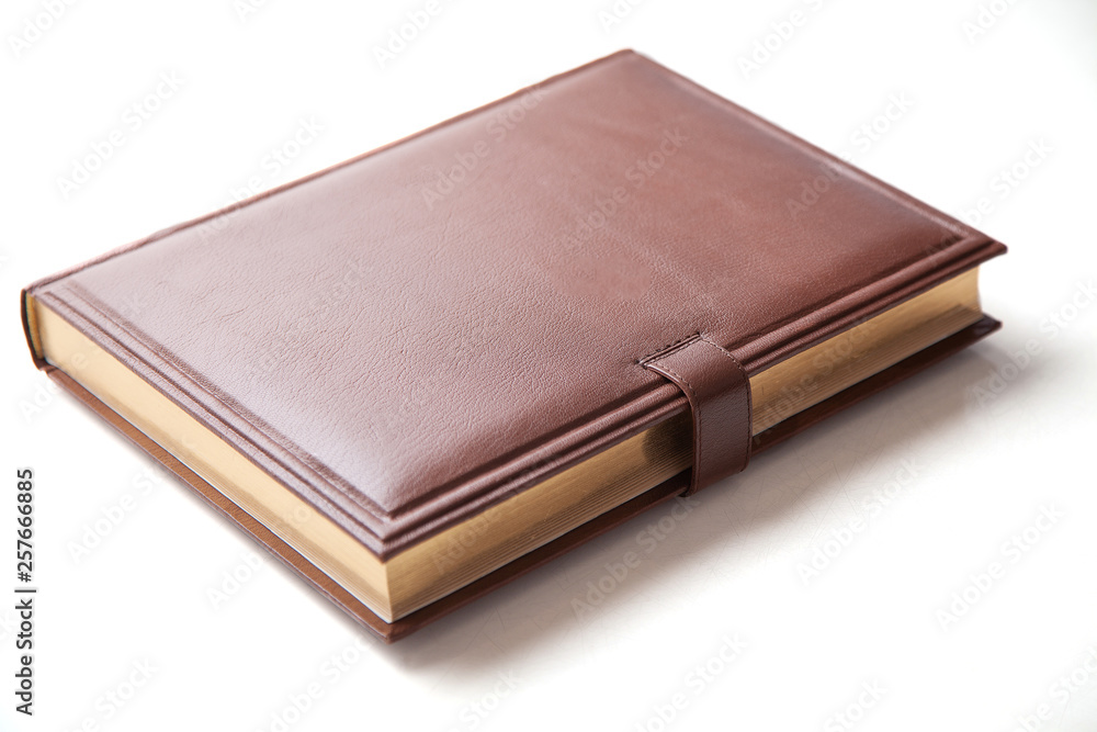 The book with a hard cover and leather cover on a white background. The book with a hard cover and leather cover on a white background.