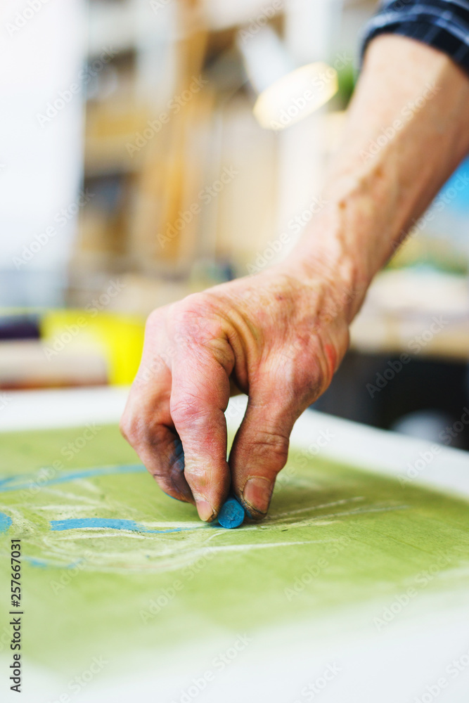Artist makes the first srihi on canvas in the process of drawing with pastel crayons. Artist makes the first srihi on canvas in the process of drawing with pastel crayons.