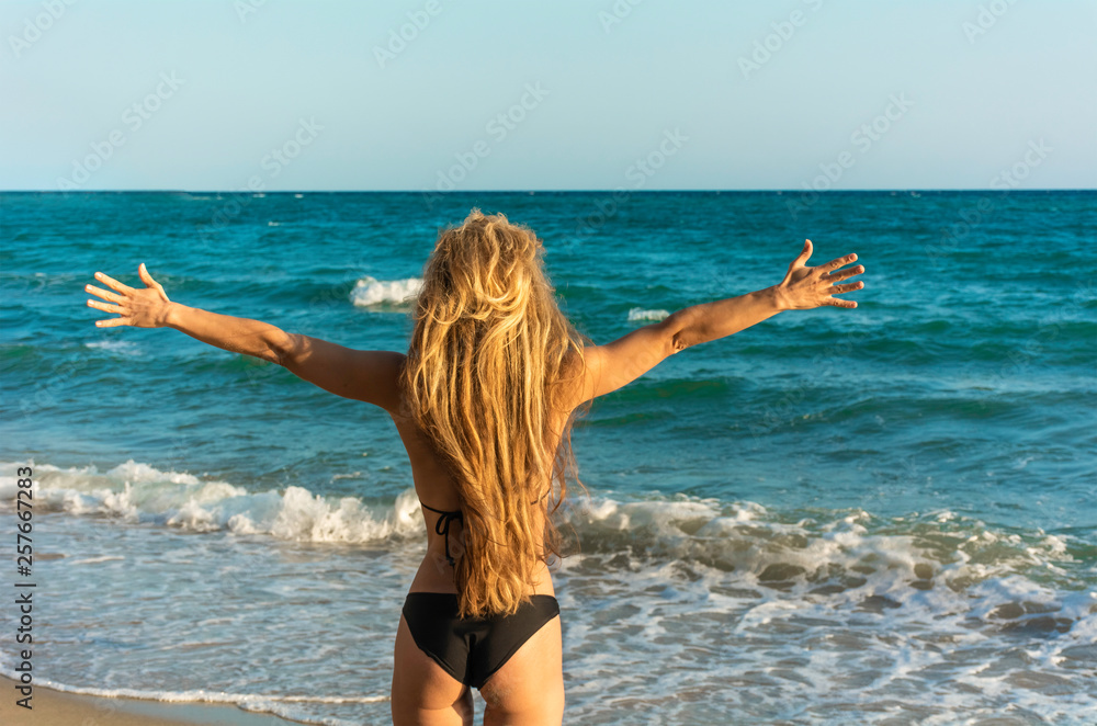Women spreading hands against endless ocean Women spreading hands against endless ocean