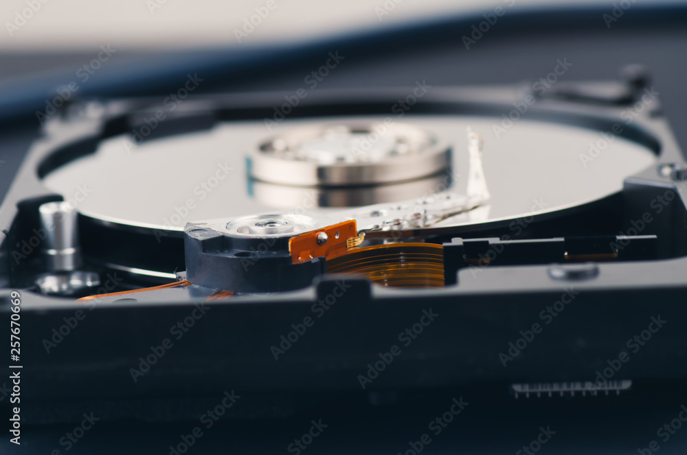 Technology and data recovery concept, stethoscope on old dusty disassembled hard drive from the computer over dark background Technology and data recovery concept, stethoscope on old dusty disassembled hard drive from the computer over dark background