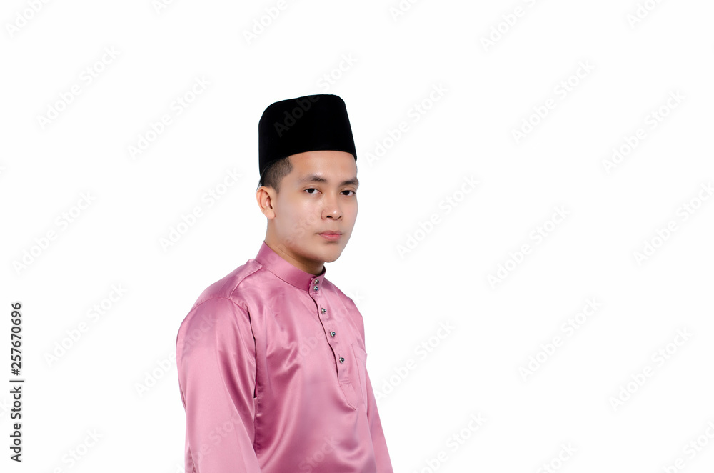 Portrait of young and handsome asian man with traditional clothing during hari raya over white background Portrait of young and handsome asian man with traditional clothing during hari raya over white background