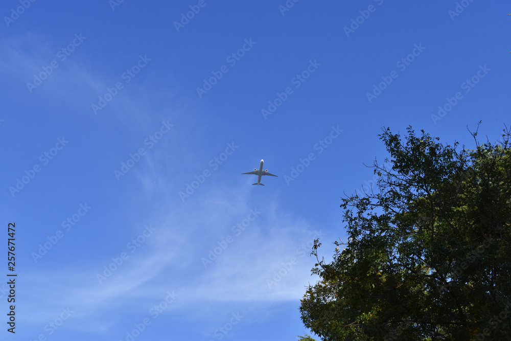 Airplane in the blue sky and cloud.The passenger plane on a background of the dark blue sky. Airplane in the blue sky and cloud.The passenger plane on a background of the dark blue sky.