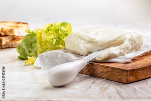 Italian spreadable cheese called stracchino served with slices of toasted bread 