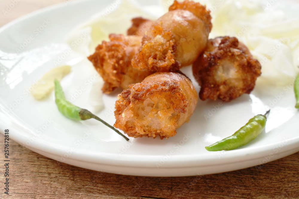 fried sour Thai sausage stuffed minced pork and glass noodles on plate