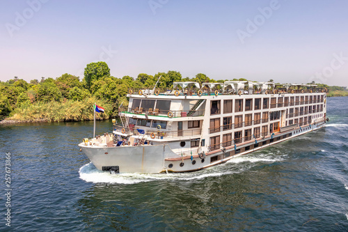 Photography A tourist boat motor down the River Nile towards Aswan in central Egypt