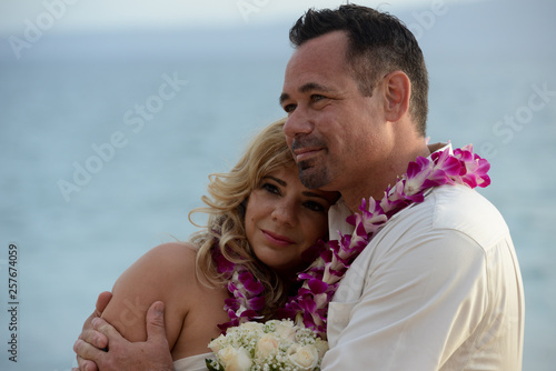 Couple embrace during wedding vow renewal ceremony on the beach in Hawaii 