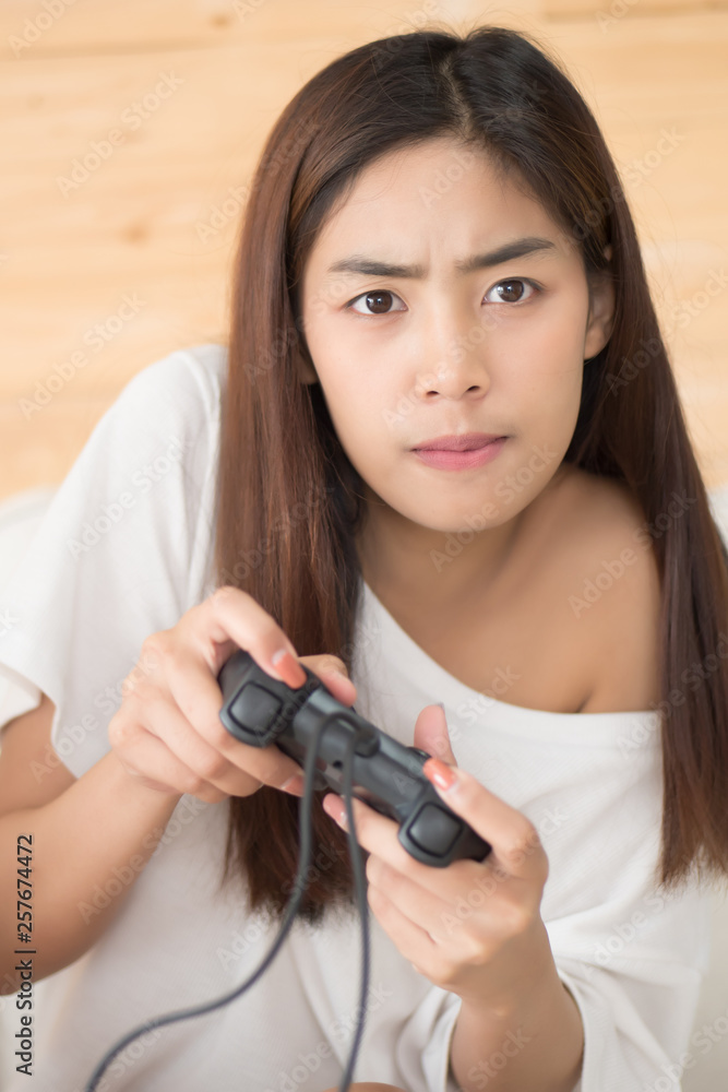 excited woman playing console video game. portrait of excited and fun asian woman plaing vdo game. hobby, liesure activity concept. asian young adult woman model excited woman playing console video game. portrait of excited and fun asian woman plaing vdo game. hobby, liesure activity concept. asian young adult woman model