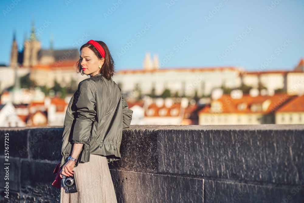 Attractive girl with retro camera on the bridge