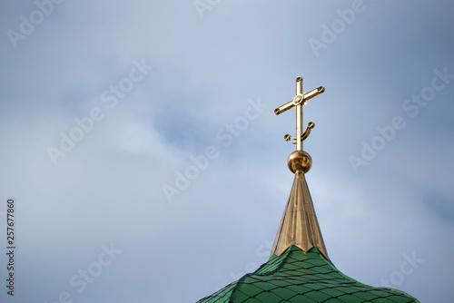 Orthodox cross with crescent at church rooftop against sky