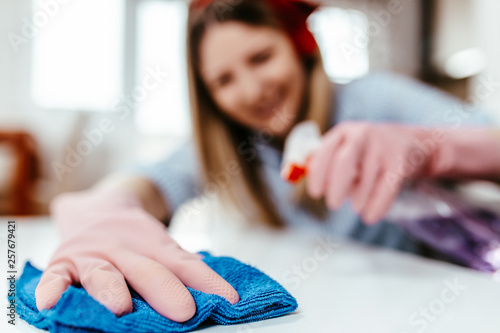 Beautiful young woman cleaning house with microfiber rag. Housekeeping concept.