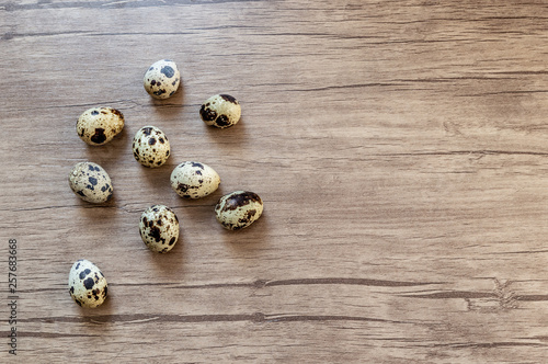 Quail eggs on brown wooden background. Flat lay, top view. Easter concept.