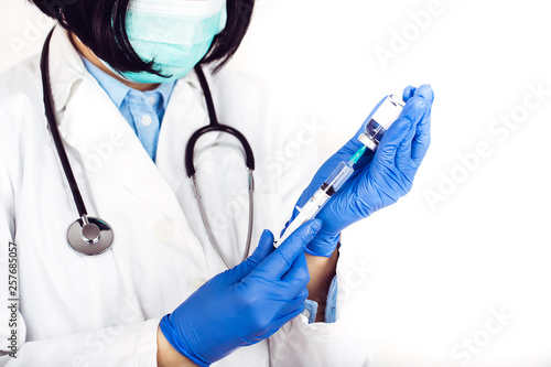 Doctor holding syringe and ampoule on white background