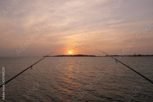 Natural and beautiful sunset with clear clouds and fishing rods in the background, at the coast of Jeddah, Saudi Arabia