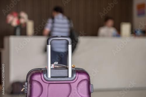 Suitcase on hotel check in counter background, reservation and travelling concept. photo