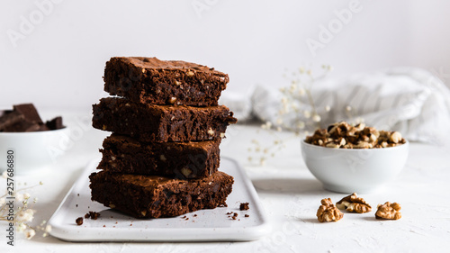 A stack of chocolate brownies on white background, homemade bakery and dessert. Bakery, confectionery concept. Side view, copy space