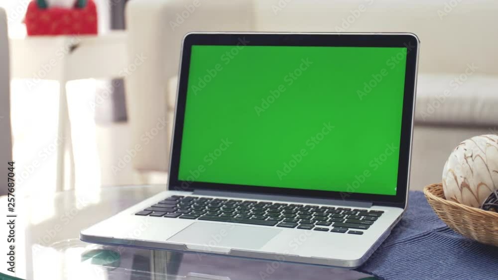 Laptop Computer Showing Green Chroma Key Screen Stands on a Desk in the Living Room. In the Background Cozy Living Room. Dolly Zoom in Shot. 4K Laptop Computer Showing Green Chroma Key Screen Stands on a Desk in the Living Room. In the Background Cozy Living Room. Dolly Zoom in Shot. 4K