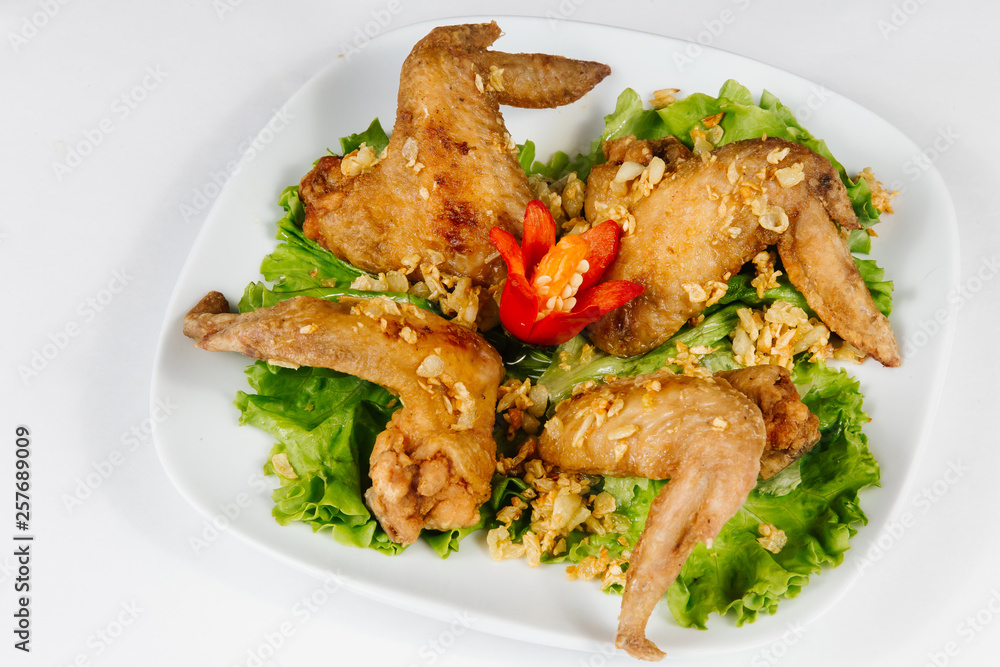 Traditional oriental cuisine of Vietnam. Breaded Chicken Wings with green salad Traditional oriental cuisine of Vietnam. Breaded Chicken Wings with green salad