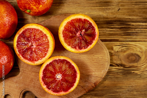 Red blood oranges on wooden table. Top view