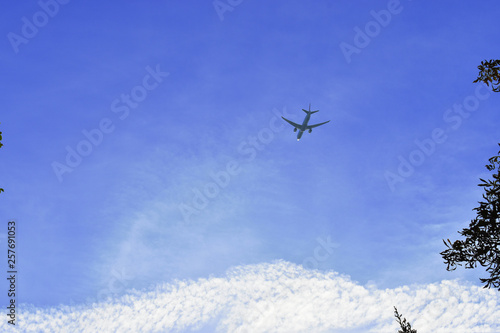 Airplane in the blue sky and cloud.The passenger plane on a background of the dark blue sky.