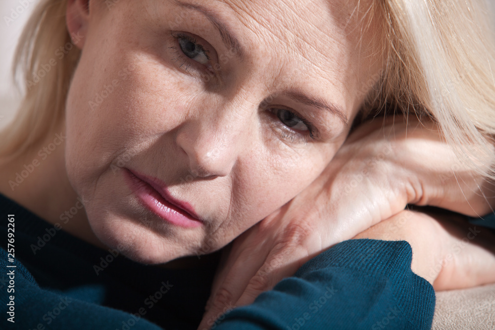 Sad woman sitting on a sofa in the living room