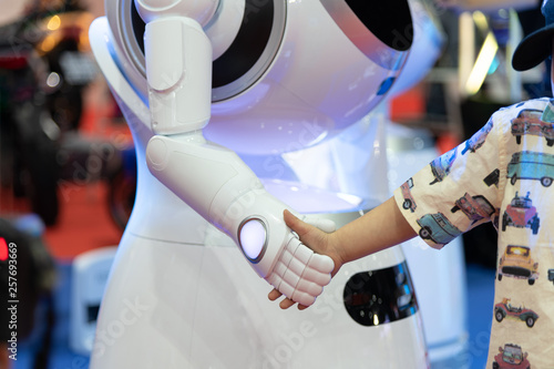 Friendly robot shaking hands with little boy, Technology smart robotic concept photo