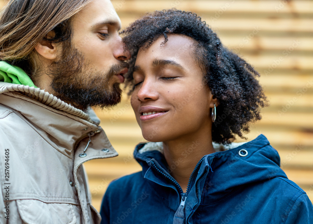 Couple in love are walking in the autumn park. Afroamerican girl with a European. Couple in love are walking in the autumn park. Afroamerican girl with a European.