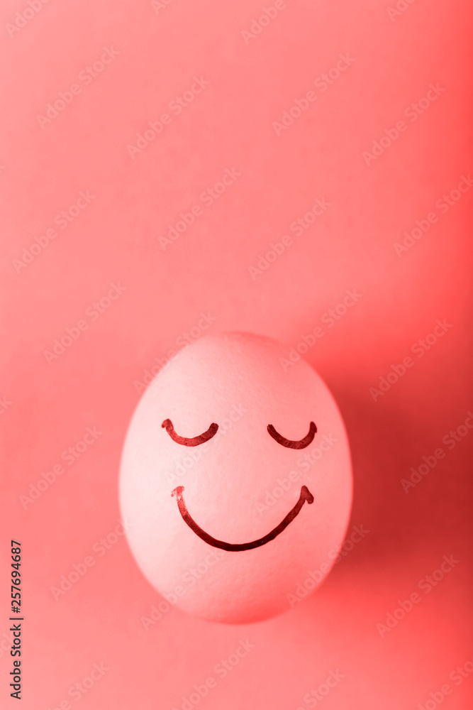 Coral egg with painted smiles. Happy Easter concept greeting card design. Coral egg with painted smiles. Happy Easter concept greeting card design.
