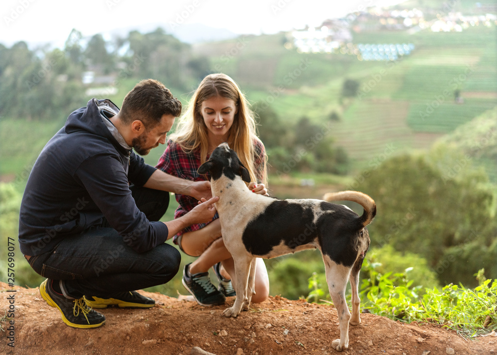 couple in love with a dog in the mountains