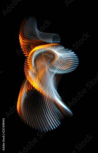 Multicolored twisted ordered parallel lines on a black background. Light in motion. Color abstraction.