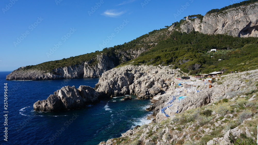 Stone beach at the mediterranean sea near the lighthouse on the island of capri