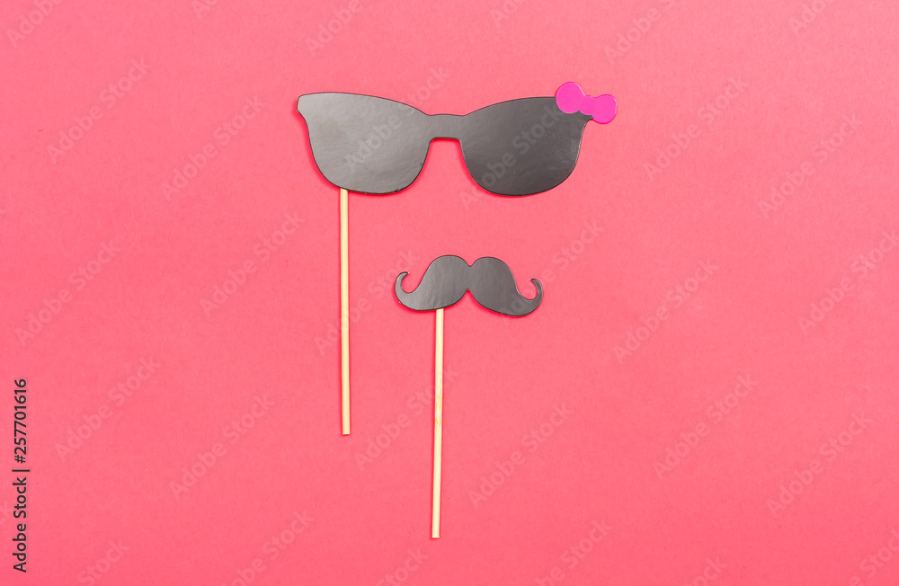 Party sticks accessories on a pink paper background Party sticks accessories on a pink paper background