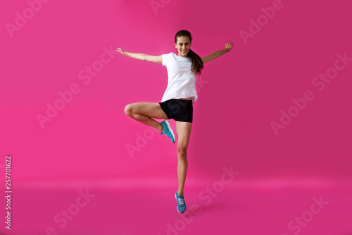 girl sportsman posing on a pink background