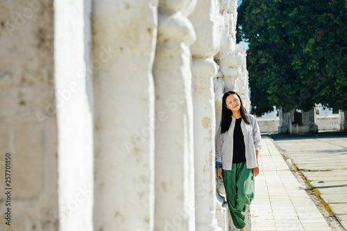 single Asian girl leans on white pagoda at Kuthodaw Pagoda, Mandalay, Myanmar © sweetriver