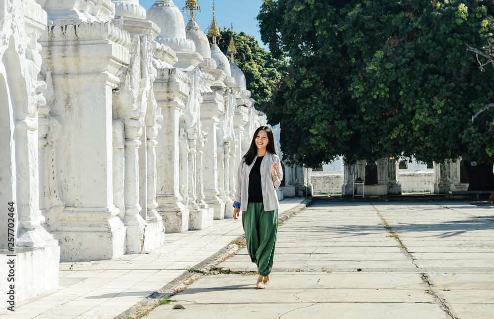 single Asian girl leans on white pagoda at Kuthodaw Pagoda, Mandalay, Myanmar single Asian girl leans on white pagoda at Kuthodaw Pagoda, Mandalay, Myanmar