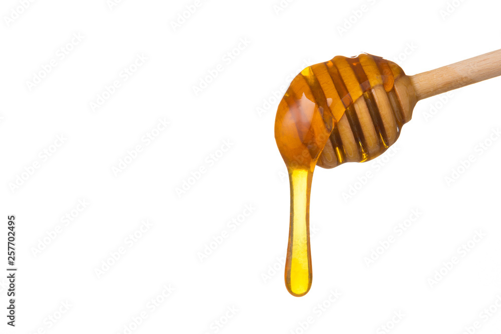 Honey dripping from wooden honey spoon Honey dripping from wooden honey spoon