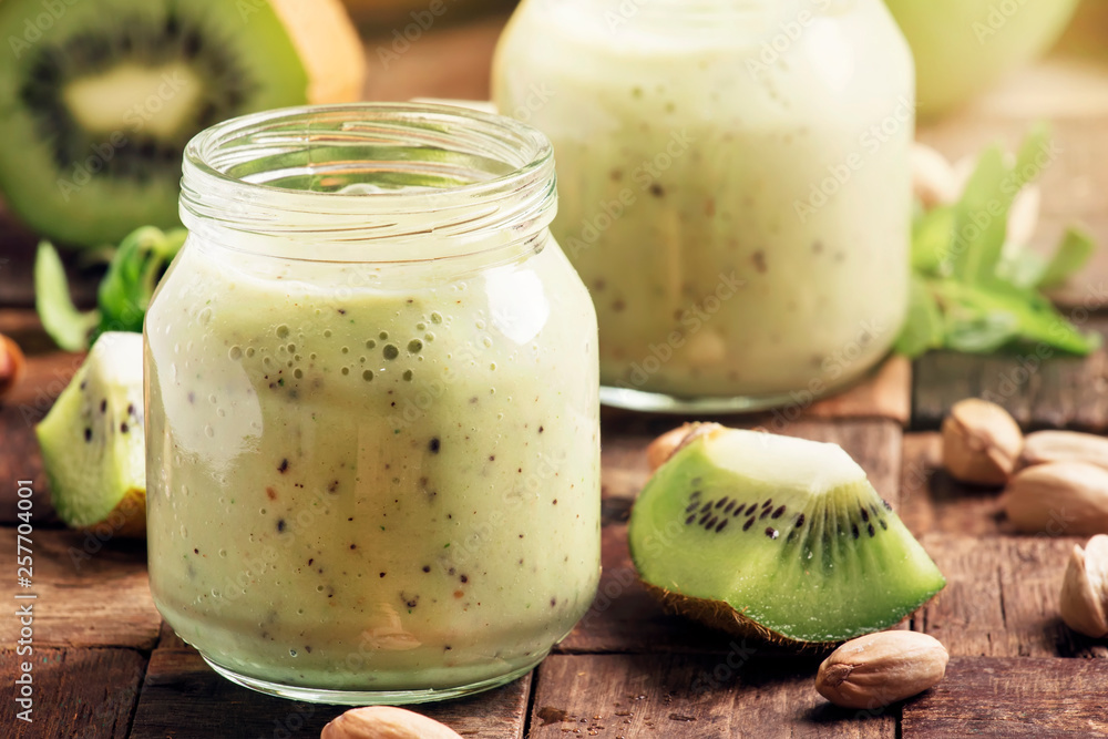 Green Smoothie with banana, kiwi fruit and pistachio, old wooden background, selective focus Green Smoothie with banana, kiwi fruit and pistachio, old wooden background, selective focus