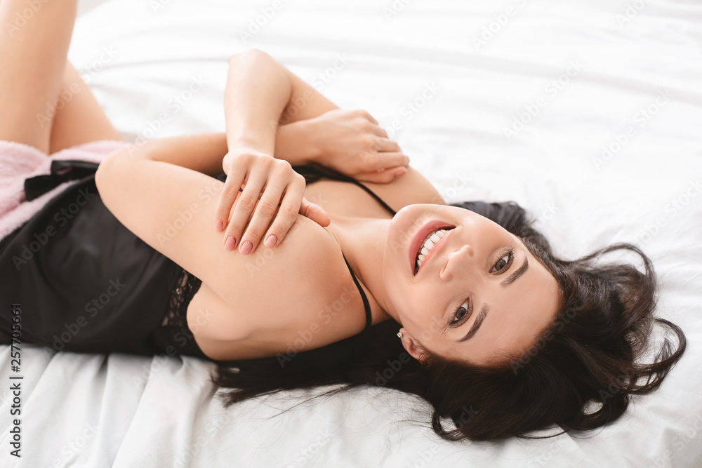 Attractive young woman smiling in bed at home Attractive young woman smiling in bed at home