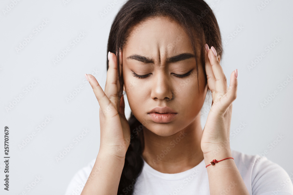 Terrible headache. Girl touching her temples, feeling stress Terrible headache. Girl touching her temples, feeling stress