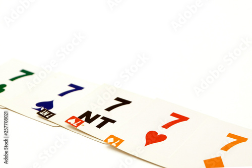 Bridge cards with 7 different suits on a white background. Equipment for a sports game of bridge. Betting concept.