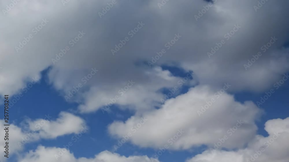 Fast flying white fluffy clouds on blue sky in timelapse video Fast flying white fluffy clouds on blue sky in timelapse video