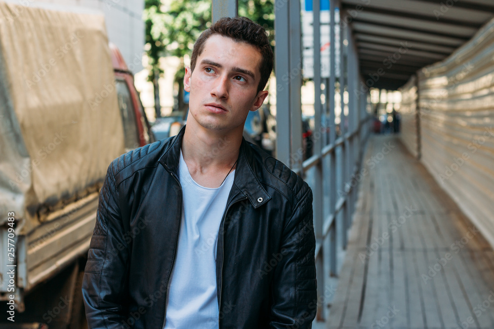 handsome, attractive guy, standing leaning on the railing in a white T-shirt, black, leather jacket, black pants handsome, attractive guy, standing leaning on the railing in a white T-shirt, black, leather jacket, black pants