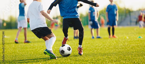 Boy kicking soccer ball. Close up action of boys soccer teams, aged 8-10, playing a football match