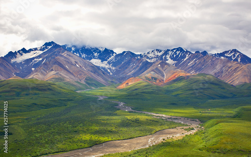 With its huge mountains and surrounded by a wonderful biodiversity lies the Denali National Park and Preserve. River, trees and cloud sky. Landscape, fine art. Parks Hwy, Alaska, EUA: July 28, 2018