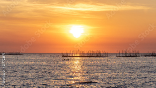 Oyster farm in the sea and beautiful sky sunset background , sun and clouds Landscape nature ,seascape at chonburi  province  Thailand © suphaporn