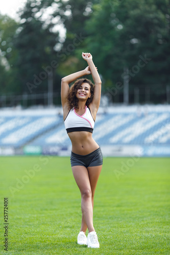 Fitness sporty girl in fashion sportswear at the football stadium, outdoor sports