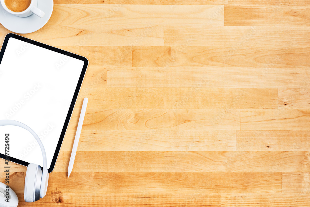 Digital tablet with blank white screen, pen, wireless headphone and cup of coffee on wooden office desk. Top view. Copy space for text or design. Flat lay. Digital tablet with blank white screen, pen, wireless headphone and cup of coffee on wooden office desk. Top view. Copy space for text or design. Flat lay.