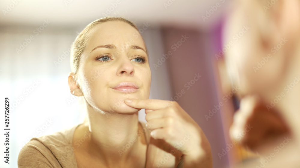 the girl looks in the mirror, dissatisfied with the appearance, pulls the skin. Ugly, aging skin. Allergy to cosmetics, fear of aging, circles under the eyes, wrinkles. Low self-esteem, dysmorphic dis the girl looks in the mirror, dissatisfied with the appearance, pulls the skin. Ugly, aging skin. Allergy to cosmetics, fear of aging, circles under the eyes, wrinkles. Low self-esteem, dysmorphic dis